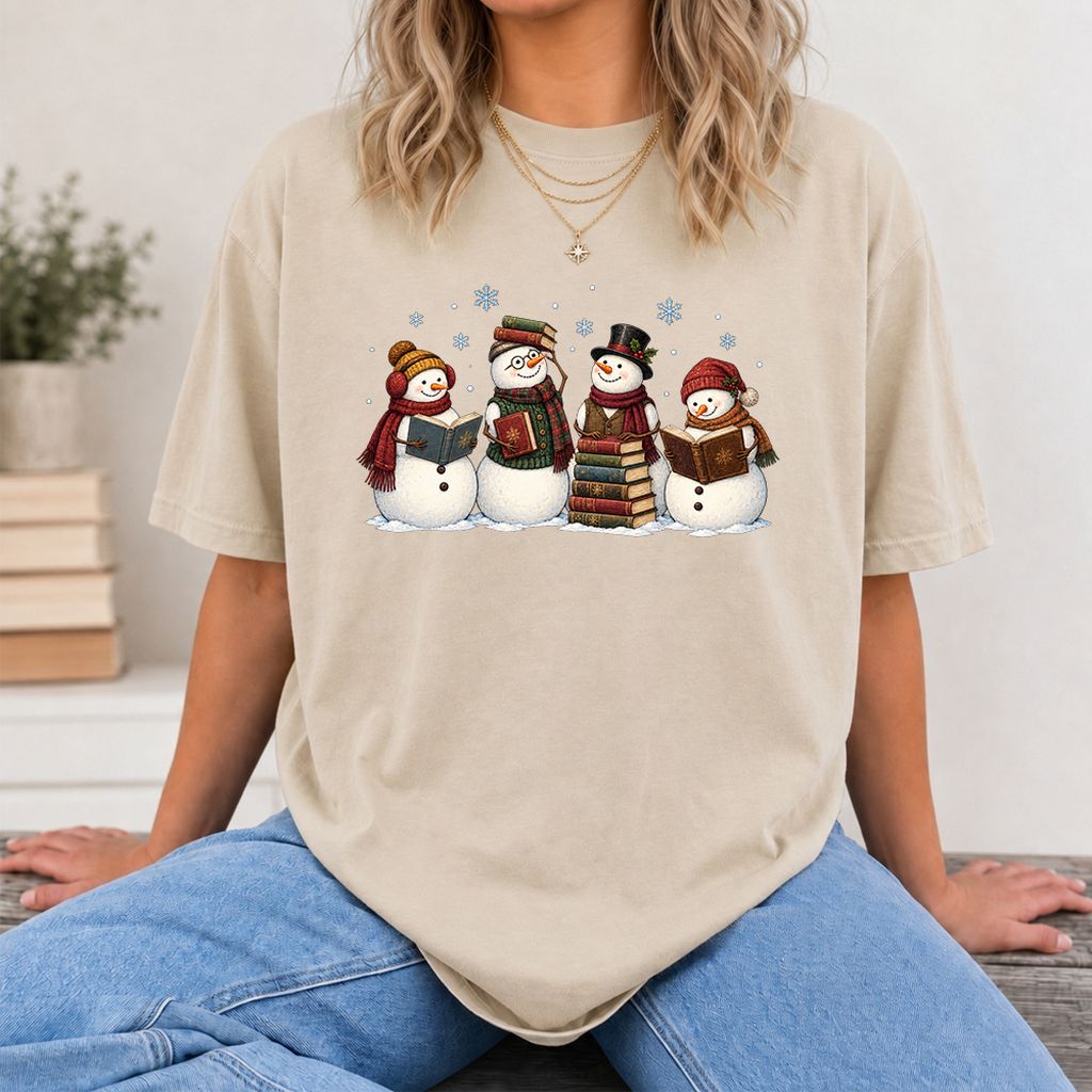 Four Snowmen Reading Printed T-Shirt | Christmas Book Lover Gift Sand