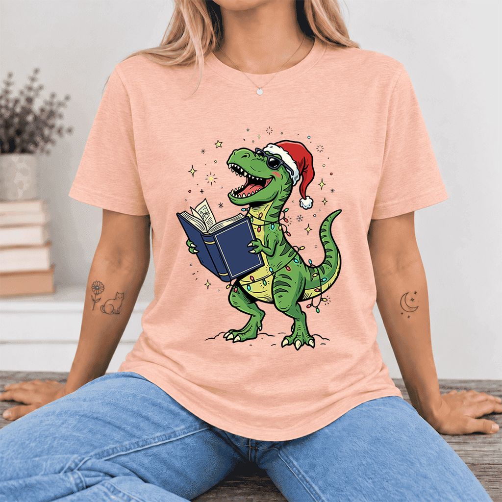 T-Rex Wearing Santa Hat And Reading Ultra-Soft Cotton T-Shirt | Christmas Gift Heather Peach