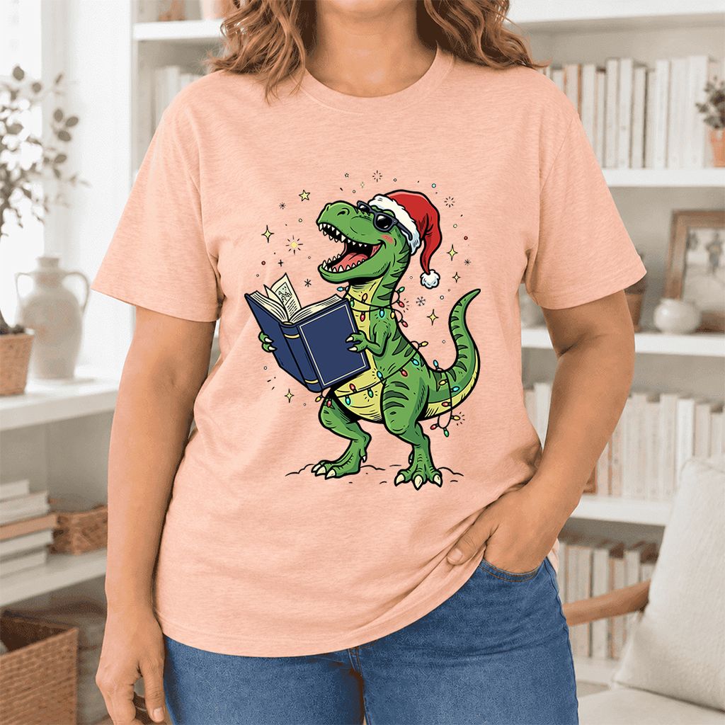 T-Rex Wearing Santa Hat And Reading Ultra-Soft Cotton T-Shirt | Christmas Gift Heather Peach