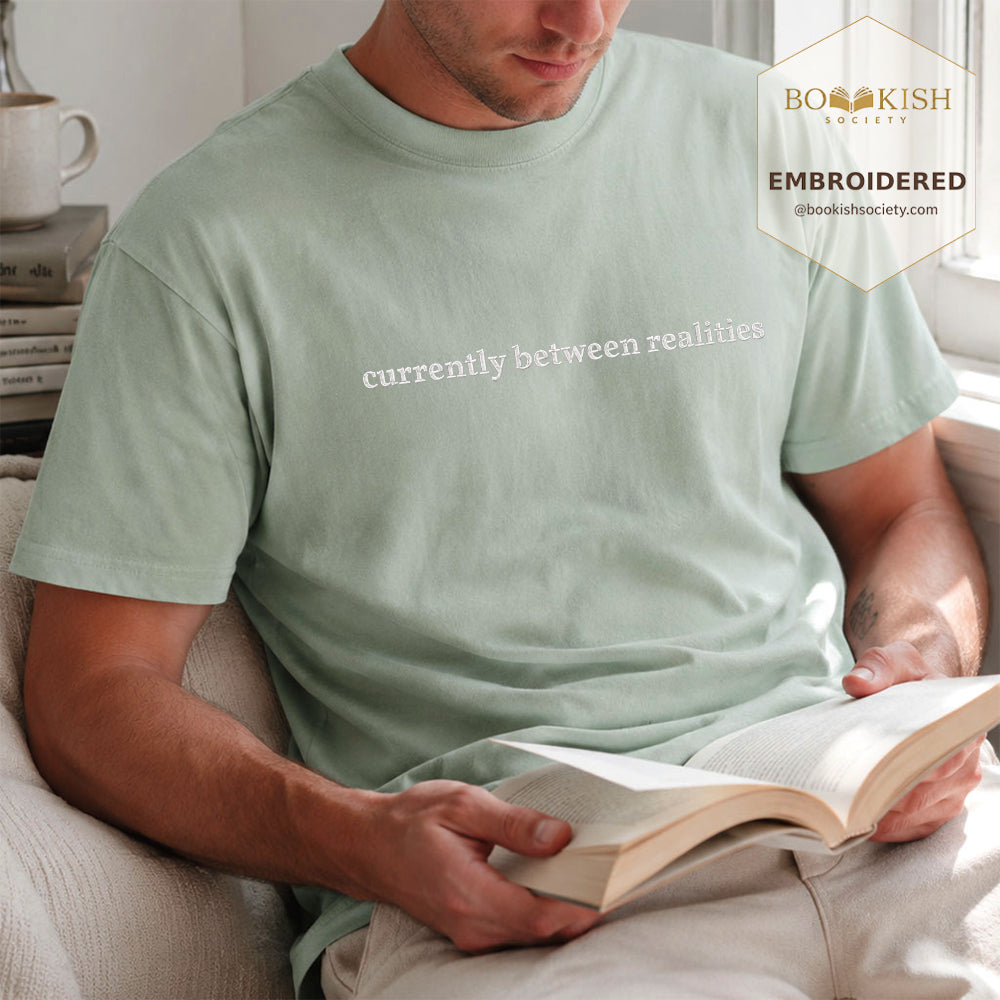 Embroidered Currently Between Realities Comfort Color® T-shirt Book Lover Gift Bay
